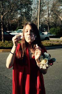 Young woman blowing bubbles at park