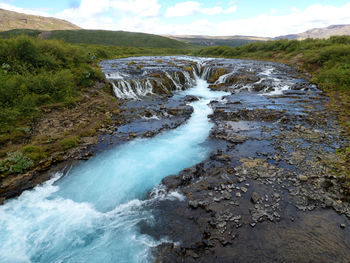 Scenic view of waterfall against sky