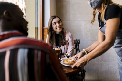 Young couple looking at while sitting on table