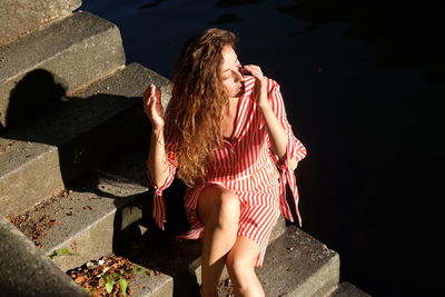 High angle view of young woman sitting on staircase