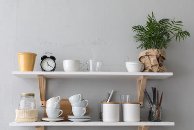 Utensils and mugs on shelf