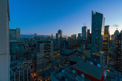 High angle view of buildings against clear blue sky