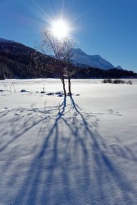 Scenic view of snowcapped mountains against bright sun