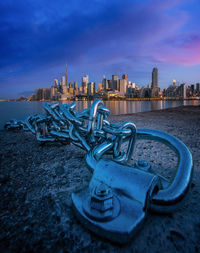 Metal structure in city against sky during sunset