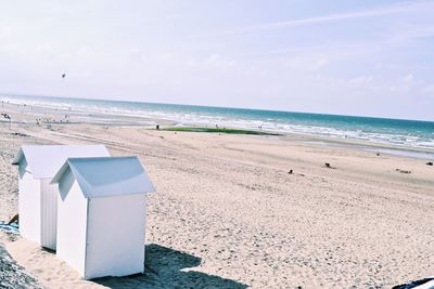 Huts at beach against sky