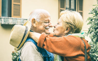 Side view of senior couple kissing outdoors