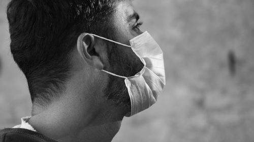 Side portrait of man wearing surgical face mask