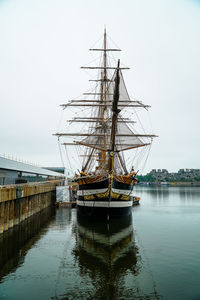 Ship moored at harbor against sky