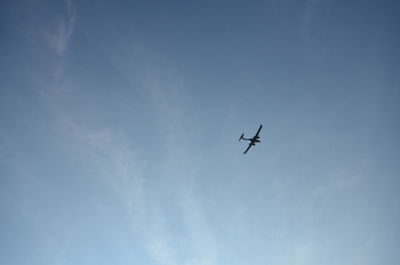 Low angle view of airplane flying against blue sky