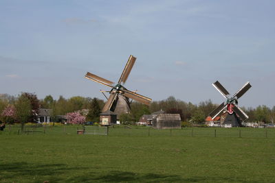 Traditional windmill on field against sky