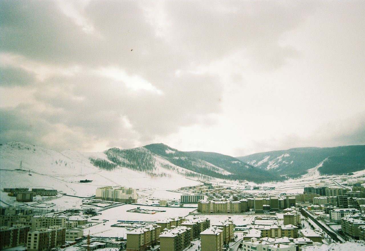 HIGH ANGLE VIEW OF TOWNSCAPE AND MOUNTAINS AGAINST SKY