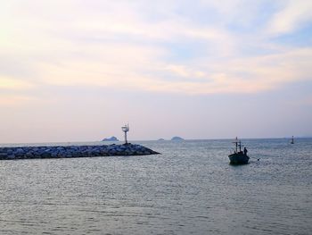 Sailboats in sea against sky during sunset