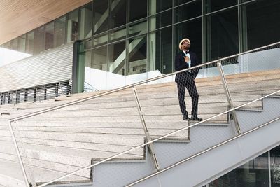 Full length of woman standing by railing