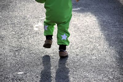 Low section of child walking on street
