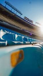 Low angel view of empty seats in stadium against sky