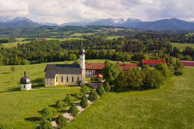 Scenic view of green landscape and mountains against sky