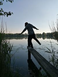 Man standing by lake against sky