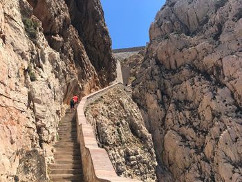 Rear view of friends climbing steps at neptune grotto