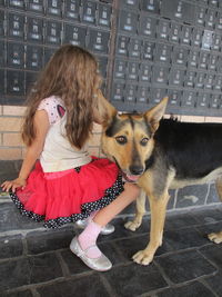 Full length of girl sitting with dog
