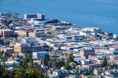 High angle view of townscape by sea against city