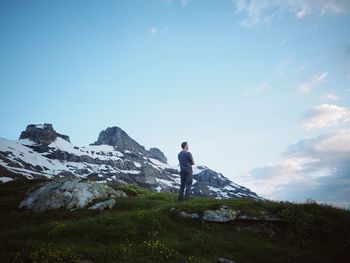 Man standing on rock against sky