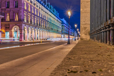 Surface level of road against buildings at night