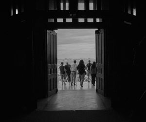 Rear view of silhouette people walking in building