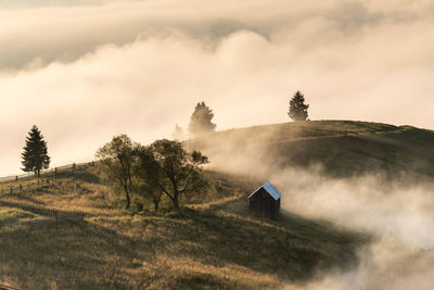 Hut on mountain against sky