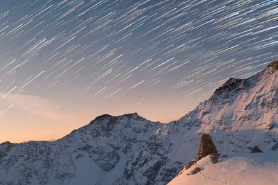 Scenic view of snowcapped mountains against sky at night