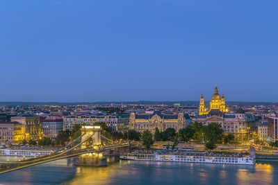 View of budapest with st. stephen's basilica and szechenyi chain bridge at dusk, hungary
