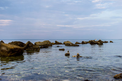 Rocks in sea against sky