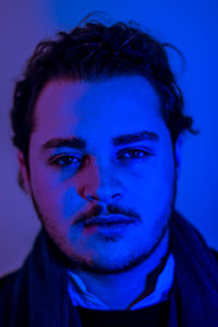 Close-up portrait of man against blue background