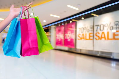 Close-up of hand holding shopping bags