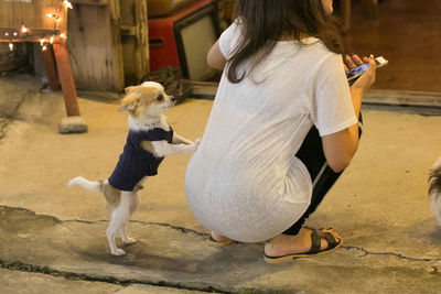 Rear view of woman with dog on floor