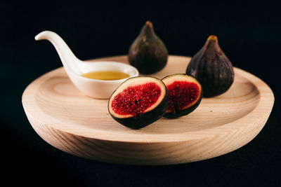 Close-up of fruits on table against black background