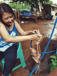 Mid adult woman sitting in a man holding a while standing outdoors