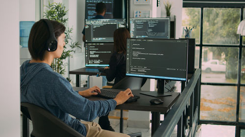 Side view of woman using laptop at home