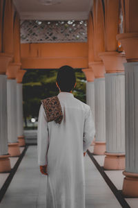 Rear view of man standing in corridor of building