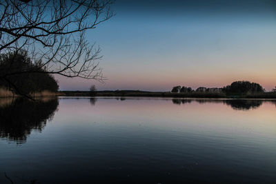 Scenic view of lake against sky at sunset