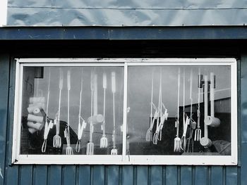 Gardening forks and sledgehammers seen through workshop window