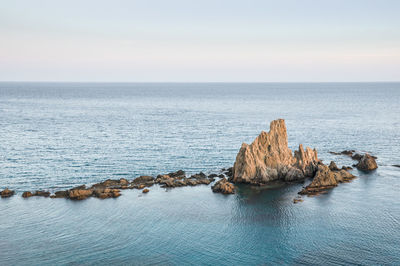 Rocks on sea shore against sky