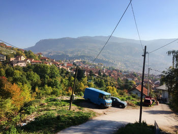 Overhead cable car over mountains against clear sky