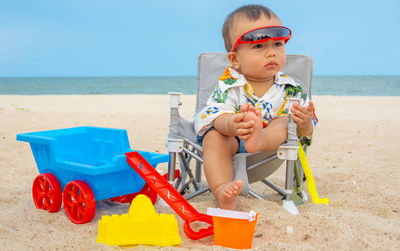 Full length of boy sitting on beach