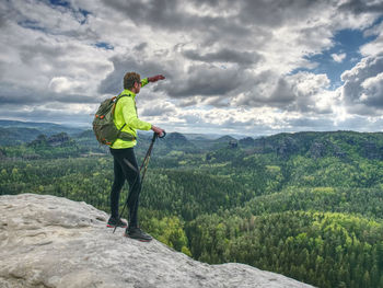 Athlete ginger hair tourist hike. wear backpack and sunglasses, use trekking sticks. tourism concept