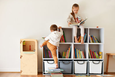 Brother and sister reading books in the children's room