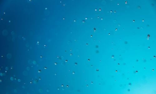 Full frame shot of raindrops on blue window