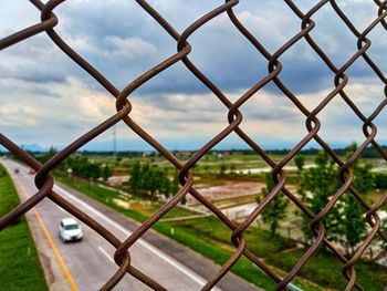 Close-up of chainlink fence against sky