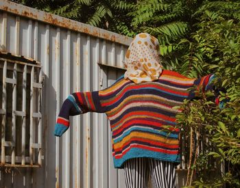 Rear view of person wearing hat standing against trees