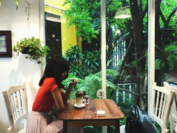 Side view of man sitting on table at cafe