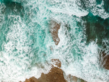 High angle view of wave splashing on rock